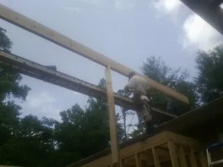 Carpenter setting a ridge beam over a new addition frame — Ice Dam Removal by Roofing Brothers in Hurleyville