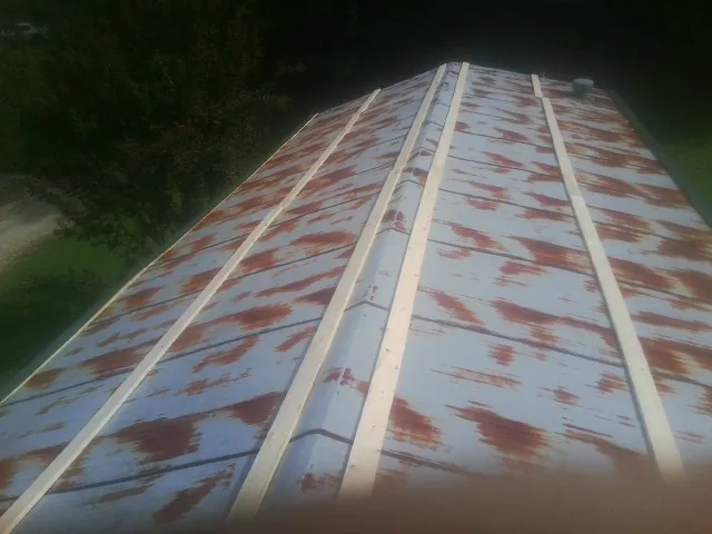 Rusted metal roof panels with new wood purlins before replacement — Storm Damage Roof Repair in Hurleyville by Roofing Brothers