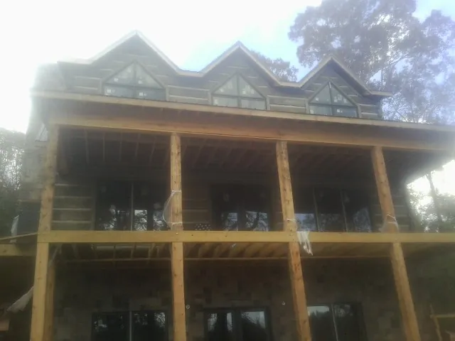 Dormers and porch framing on a large log home under construction — Roof Coating work by our crew in Hurleyville