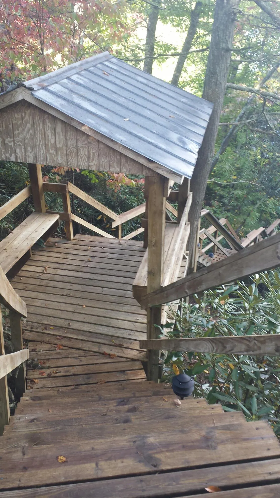 Metal roofed shelter over wooden steps on a wooded walkway — Skylight Repair & Installation work by our crew in Hurleyville
