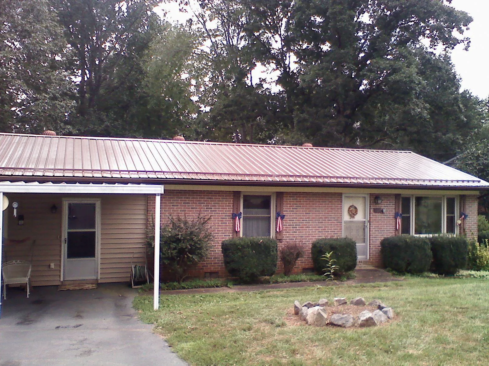Bronze metal roof and carport on a brick ranch home — Roof Repair work by our crew in Hurleyville